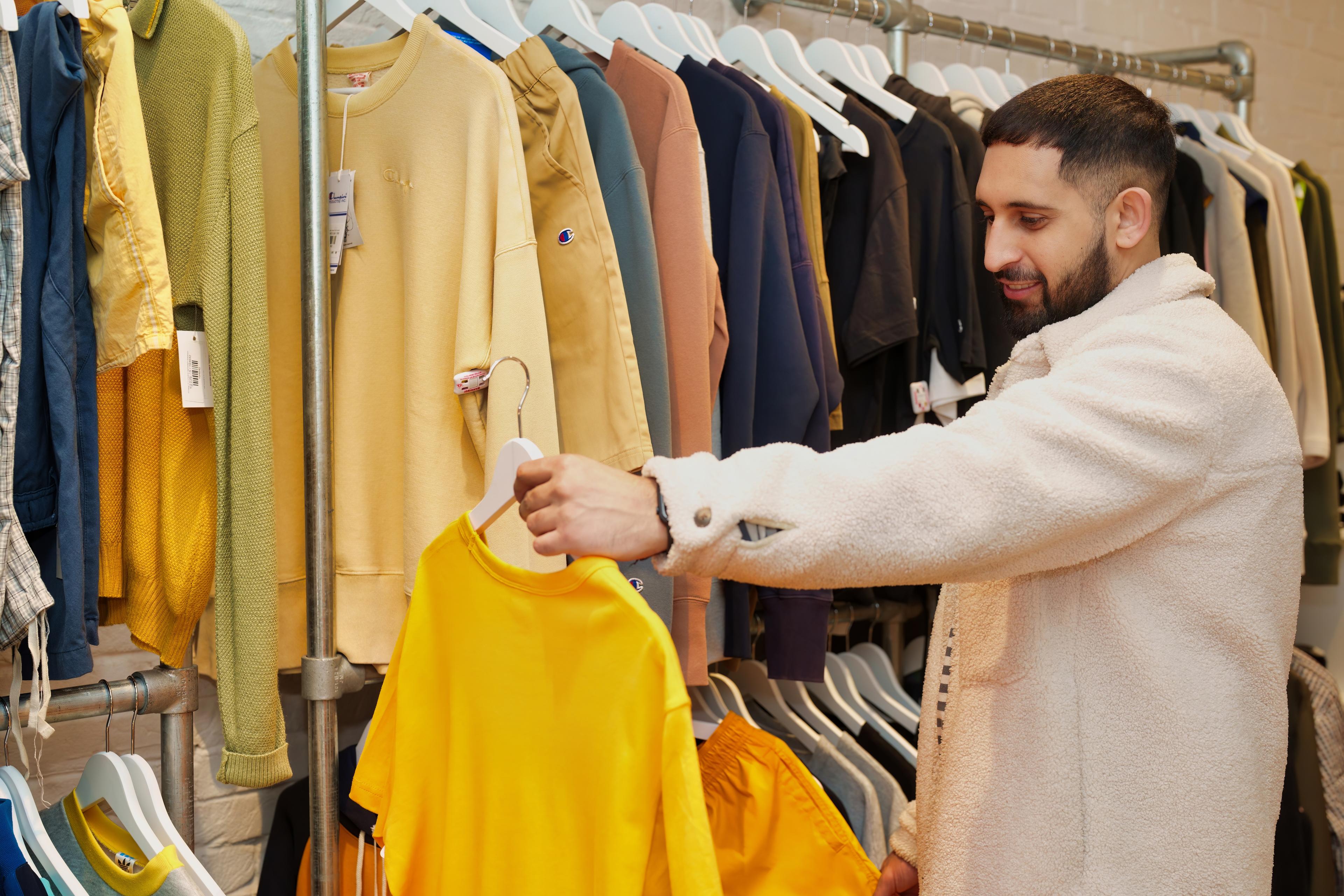 A photo of a man browsing clothes in a shop
